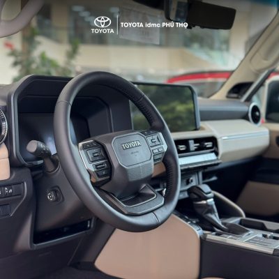 Khoang lái hiện đại của Toyota Prado 2025 với vô lăng ốp gỗ và màn hình giải trí trung tâm.